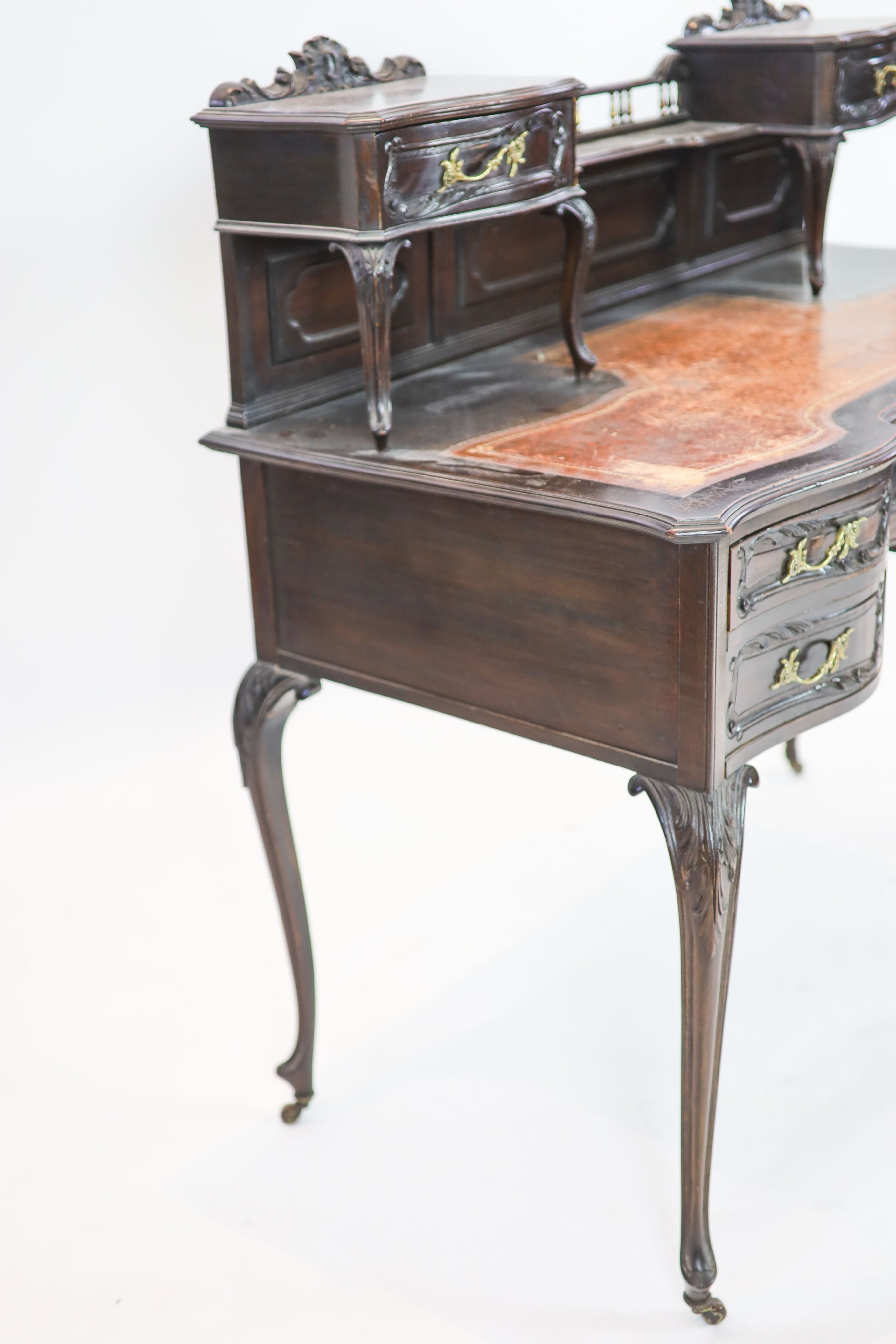 A late Victorian carved mahogany serpentine-shaped writing desk, length 106cm, depth 54cm, height 105cm